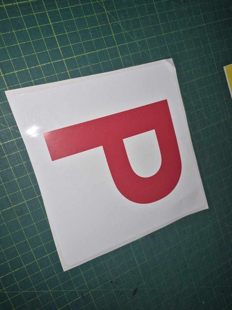 Red 'P' letter on a white background on a green cutting mat