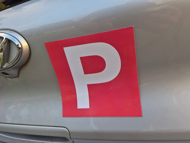 Red square magnet with white 'P' on a car, indicating a Provisional driver.
