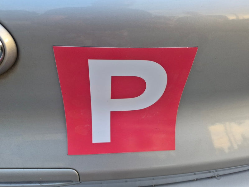 Red and white 'P' magnetic plate on a car, indicating a Provisional driver.