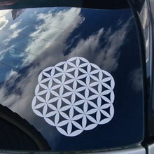 Load image into Gallery viewer, White flower of life symbol on a car window with a blue sky reflection.
