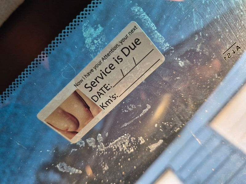 Close-up of a label on a blue surface with text and a foot image.