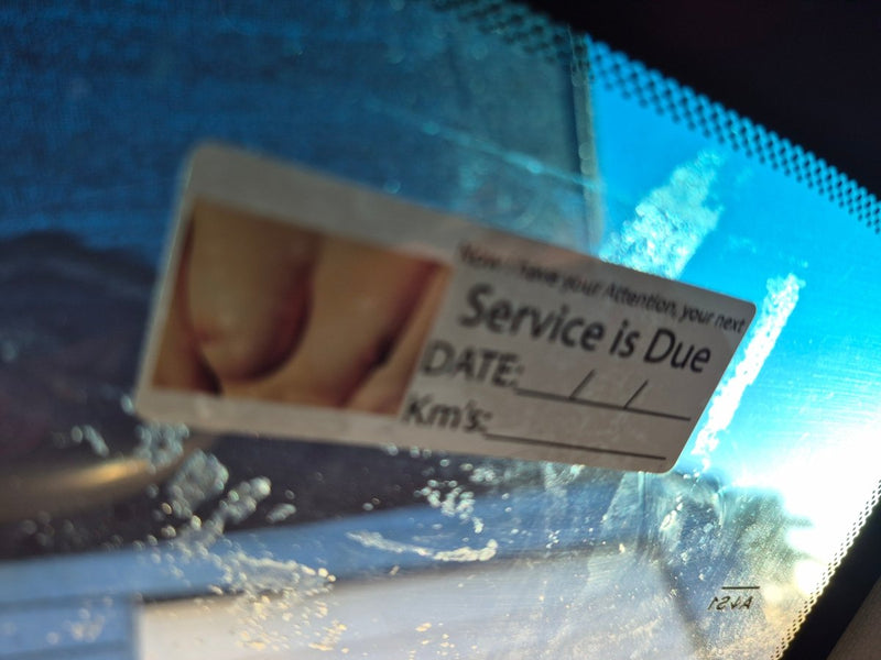 Service due card on a car windshield with a blurred background