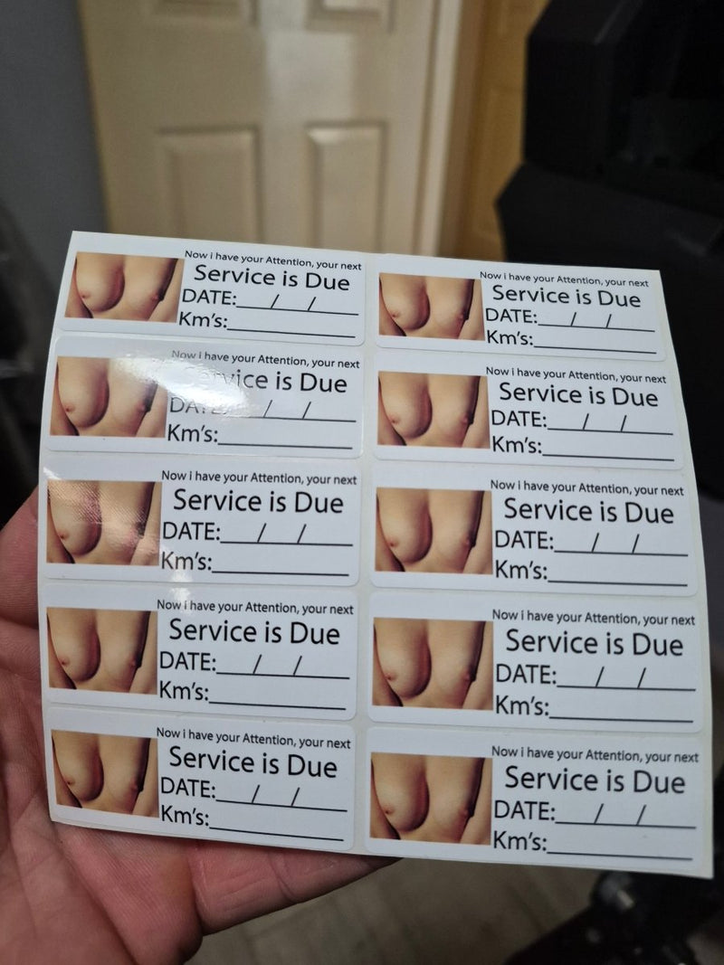 Sheet of car maintenance stickers with 'Service is Due' text held by a hand.