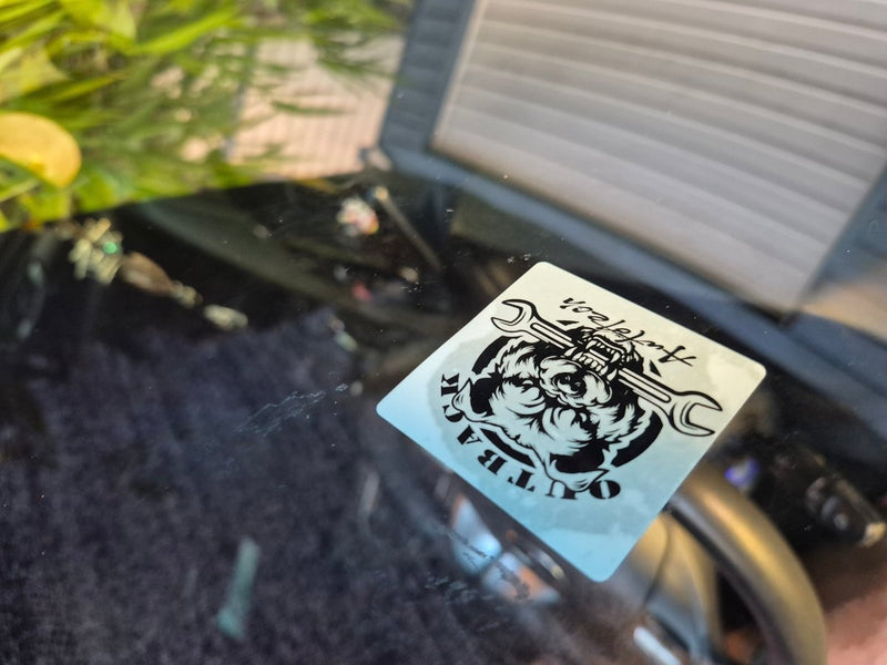 Service die Sticker with a Customer logo design and text on a vehicle's window.