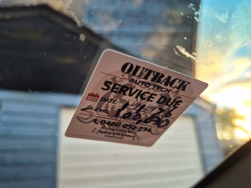 Service due sticker on a car window with blurred background