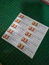 Load image into Gallery viewer, Sheet of 'Service is Due' labels with images of feet on a green cutting mat.
