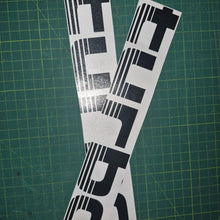 Load image into Gallery viewer, Two black and white decals with 'TURBO' text on a green cutting mat.
