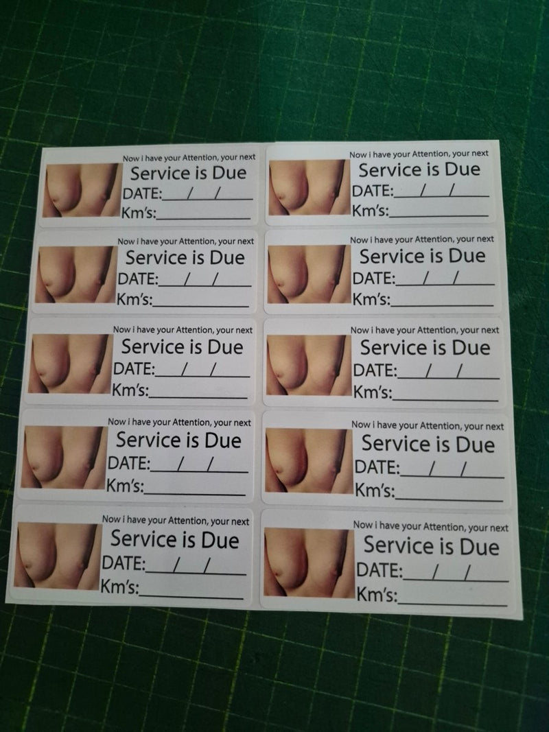 Sheet of printed labels with 'Service is Due' text and images on a green cutting mat.