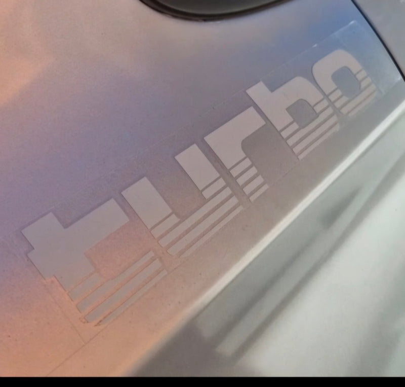 Close-up of a 'Turbo' decal on a vehicle's surface.