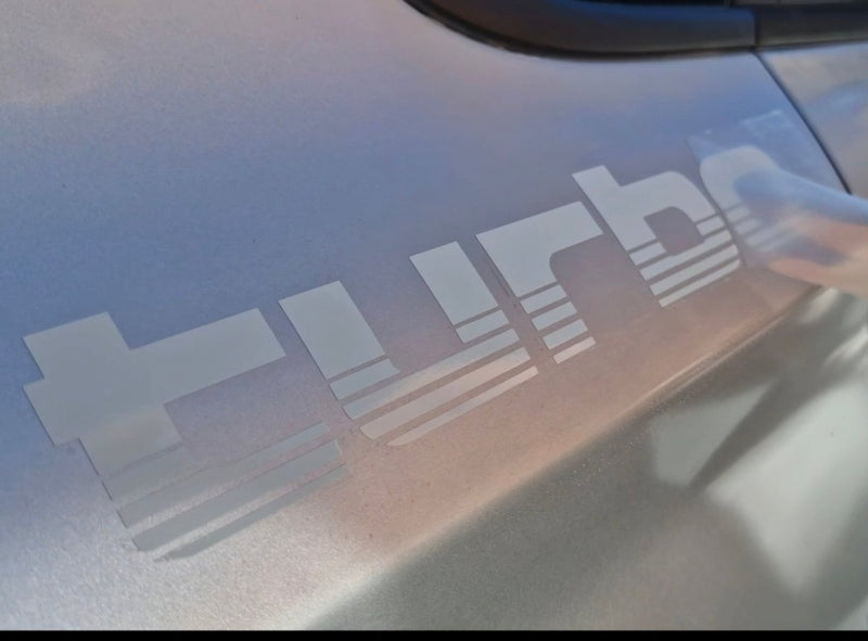 Car window with 'Turbo' decal on a reflective surface