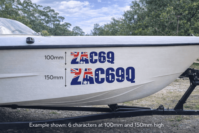 Boat with Australian flag-themed registration number decal on a grassy area.