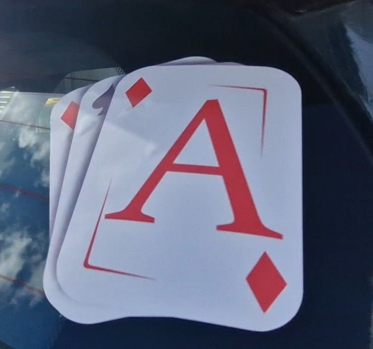 Four playing cards, including an Ace of Diamonds, on a reflective surface.