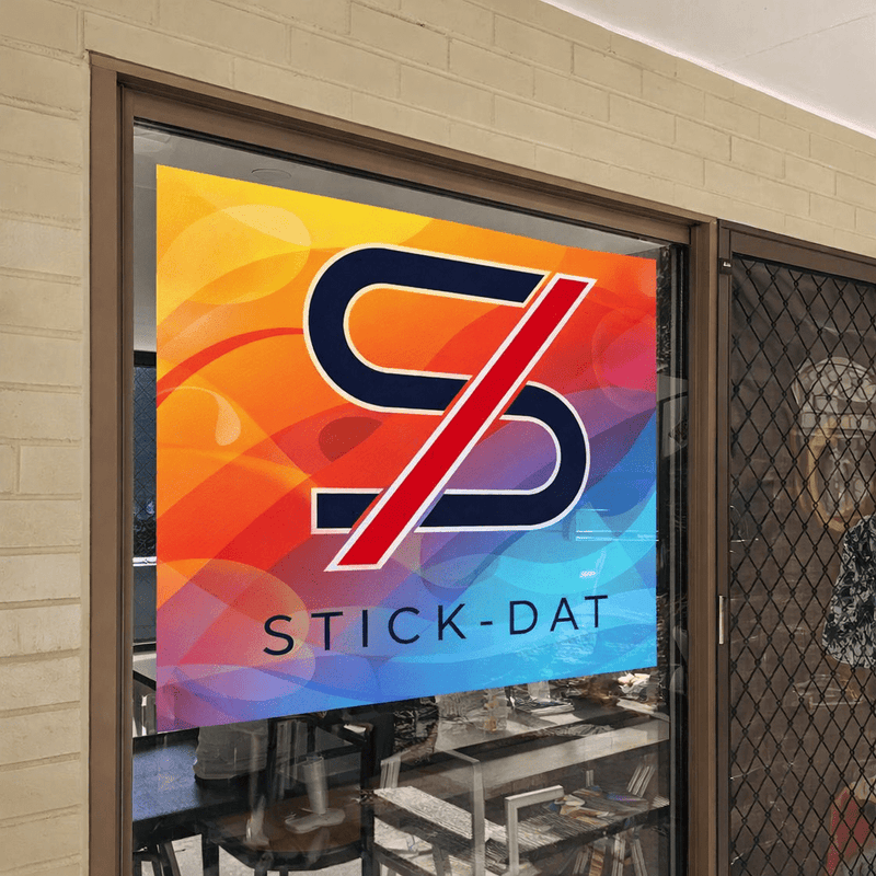 Colorful 'Stick-Dat' logo on a glass door with a blurred interior background