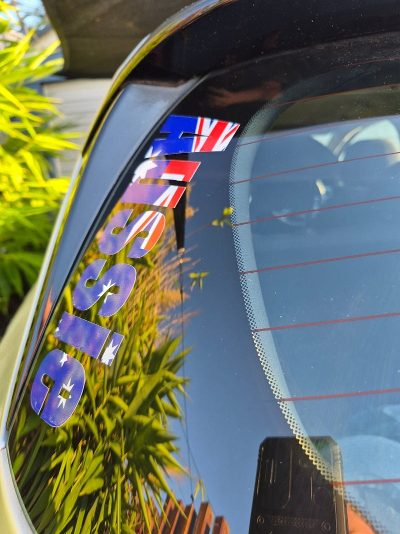 Reflective surface with ' aussie' text and British flag, surrounded by greenery.