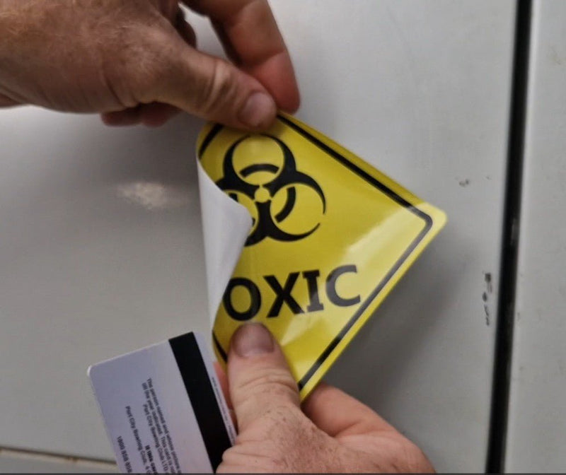Person affixing a biohazard sign to a surface