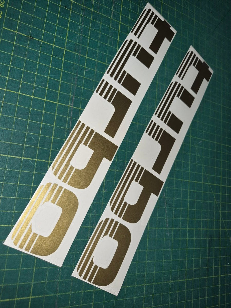 Two 'Turbo' decal stickers on a green cutting mat.