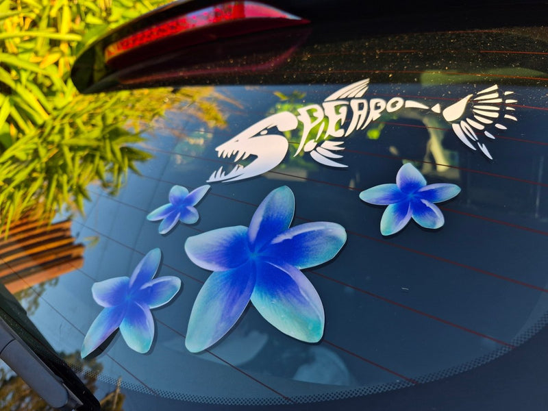 Car window with blue Frangipani flower decals and a white logo