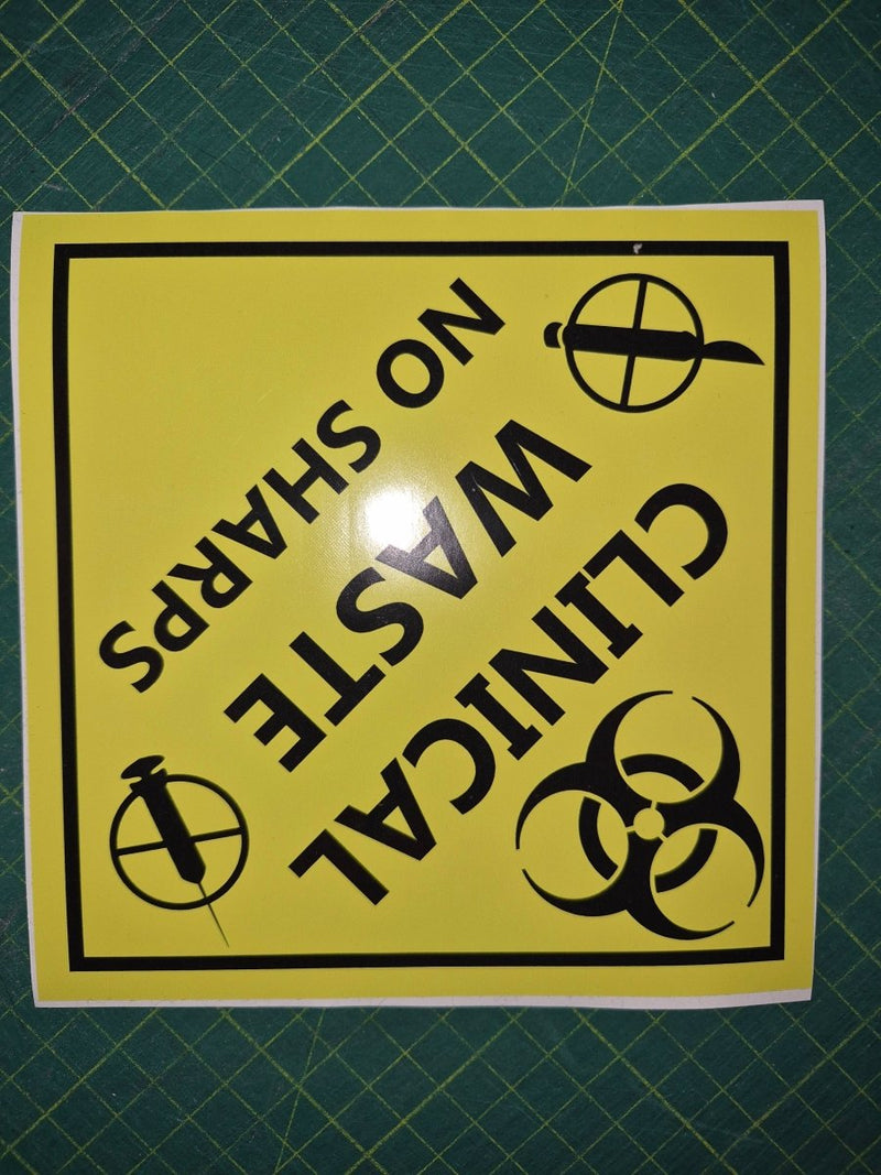 Yellow sign with black text and symbols on a green grid background
