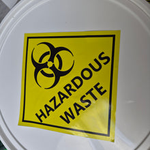 Load image into Gallery viewer, White container lid with a hazardous waste label featuring a biohazard symbol.
