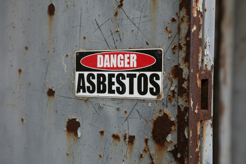 Danger Asbestos close-up on metal door