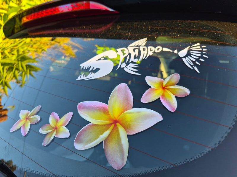 Floral yellow frangipani stickers on a car window with a visible brand logo.