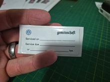 Load image into Gallery viewer, Close-up of 65x30mm double-sided service due sticker showing reverse side with service date and business contact information
