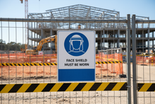 Load image into Gallery viewer, Face Shield on construction fence
