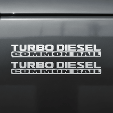 Load image into Gallery viewer, Flat silver-grey Turbo Diesel Common Rail stickers on dark background
