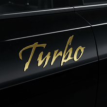Load image into Gallery viewer, Gold Gothic Turbo sticker on black panel
