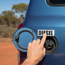 Load image into Gallery viewer, Hand applying diesel sticker to 4WD fuel cap door
