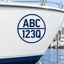 Load image into Gallery viewer, Navy cut-vinyl round boat registration decal on a white hull
