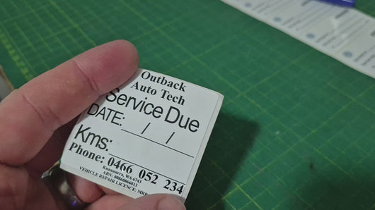 Double-sided service due sticker demonstration showing front and back custom logo design for automotive workshops