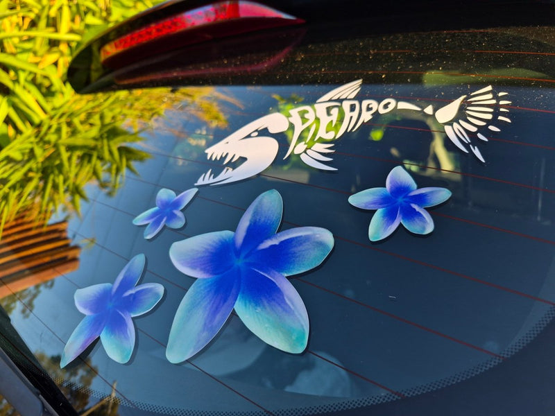 Frangipani Car window with blue flower decals and a bird design sticker.