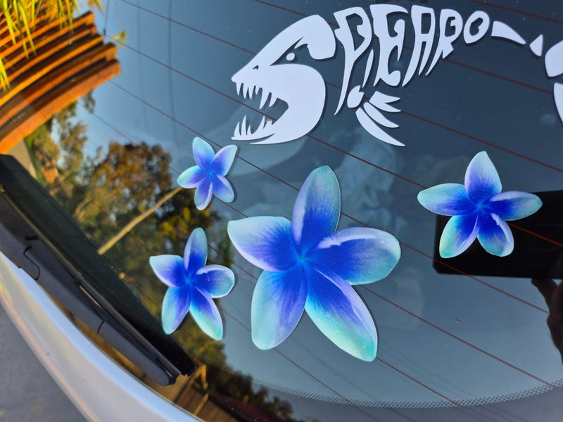 Frangipani Blue flower decals on a car window with a shark decal above them.