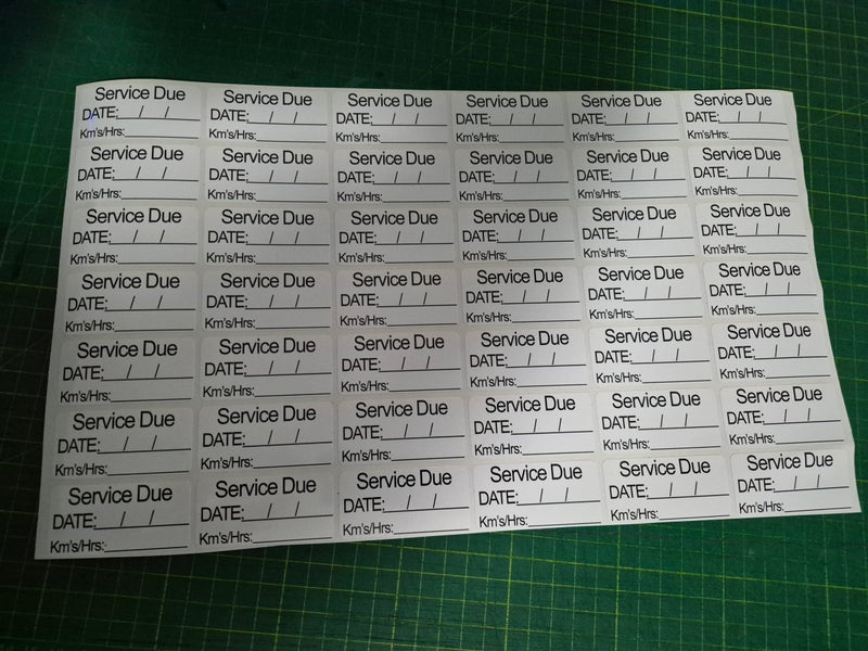 Sheet of 'Service Due' labels with pre-printed text on a green cutting mat.