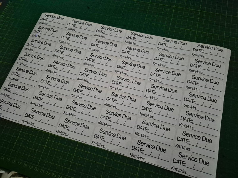 Sheet of labels with 'Service Due' text on a green cutting mat
