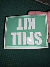 Load image into Gallery viewer, Hand holding a green sign with 'SPILL KIT' text on a grid background
