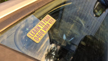Load image into Gallery viewer, Yellow Learn to park wanker sticker sticker on a car windshield with reflections.
