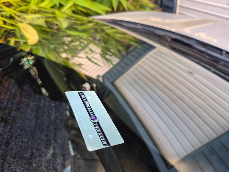 Car Service due decal with a brand label on a car interior window seen from the outside of the vehicle  