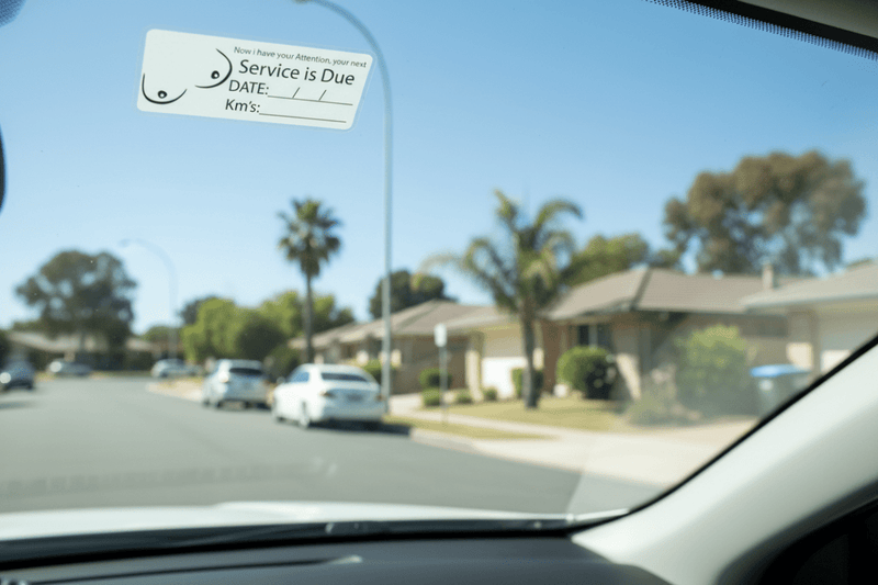 Service due sticker on car windscreen suburban