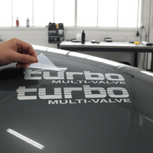 Load image into Gallery viewer, Silver Turbo Multi-Valve sticker being applied with transfer tape peeling back
