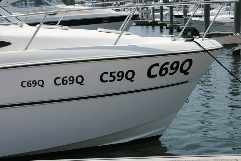 Three rego sticker sizes on boat hull marina