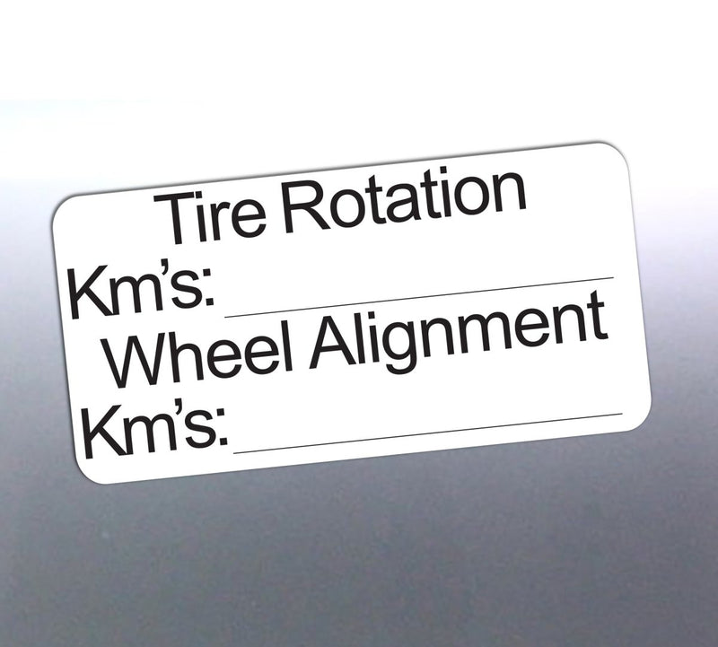 Label for tire rotation and wheel alignment with fields for kilometers on a reflective surface.