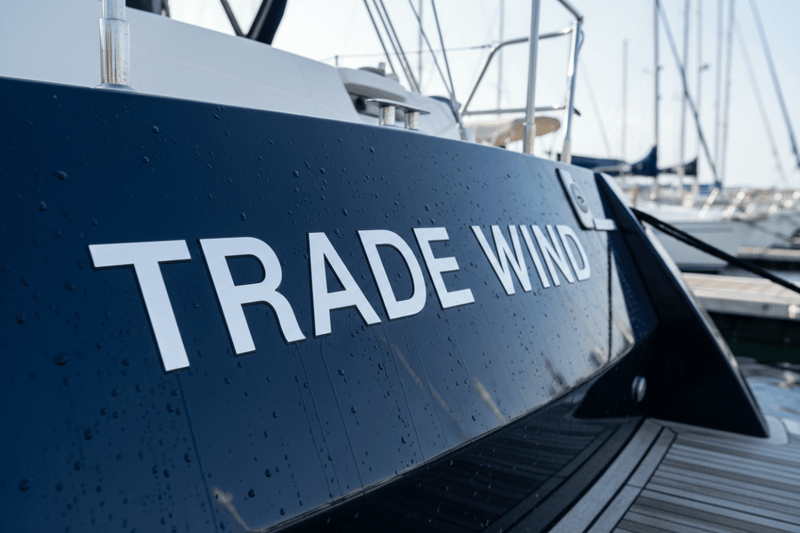 Trade Wind - navy hull close-up white block letters