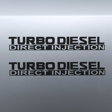 Load image into Gallery viewer, Two black Turbo Diesel Direct Injection stickers stacked on grey panel

