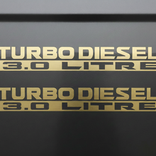 Load image into Gallery viewer, Two matte gold Turbo Diesel 3.0 Litre stickers stacked
