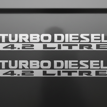 Load image into Gallery viewer, Two satin silver Turbo Diesel 4.2 Litre stickers stacked
