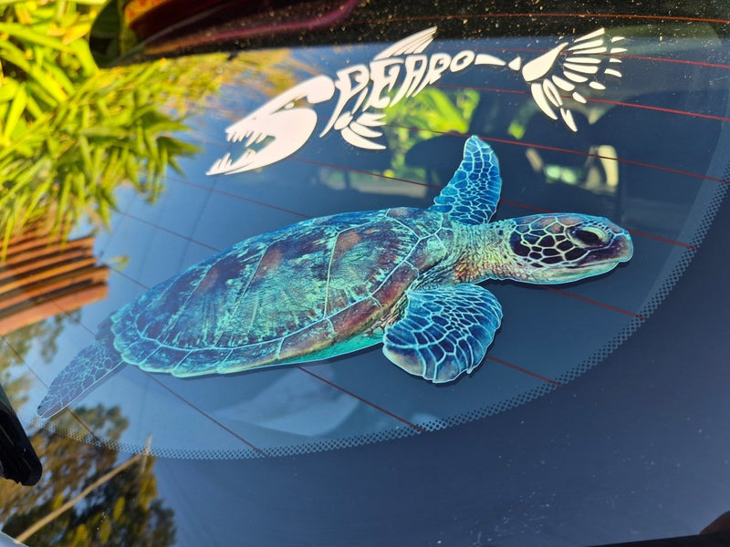Turtle decal on a car window with a logo in the background