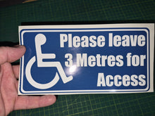 Load image into Gallery viewer, Hand holding a sign with wheelchair icon and text 'Please leave 3 Metres for Access' on a green cutting mat.
