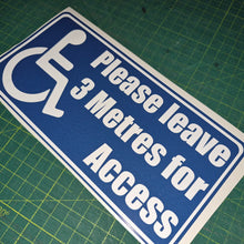 Load image into Gallery viewer, Blue and white sign with wheelchair icon and text on a green cutting mat
